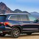 A photo of a navy blue Honda Passport crossover with mountains behind.